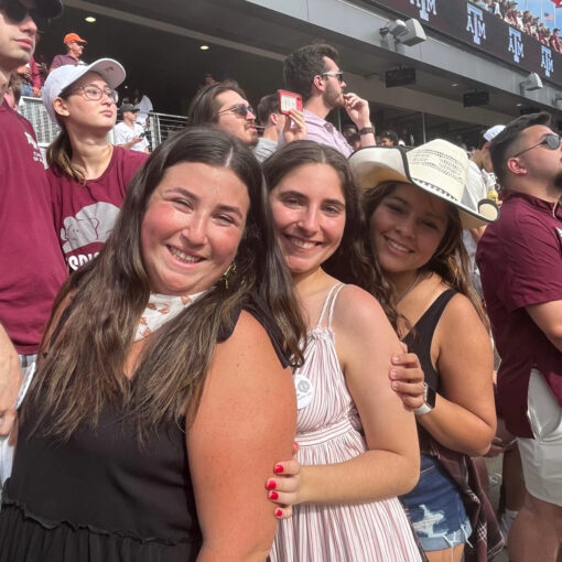 Three CPC members smiling and posing in a row inside Kyle Field