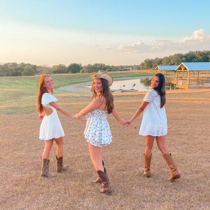 Three CPC members holding hands and looking back while outside